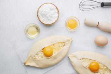 Khachapuri 'nin yumurta sarısı ve unu beyaz masada.