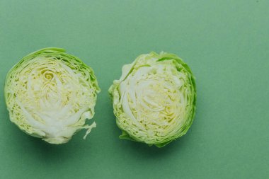 Yeşil arka planda iç dokuyu gösteren yarım yeşil lahana.