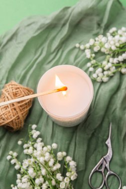 Çiçekli yanan mum ve yeşil arka planda hediye