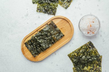 Beyaz arka planda bir kase tuzlu kavrulmuş yosun atıştırmalığı