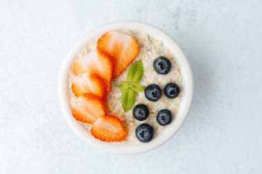 Beyaz arka planda yulaf ezmesi, çilek ve yaban mersini manzarası