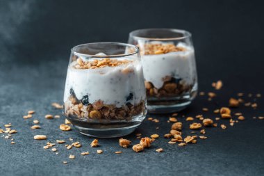 Koyu arkaplanda granola ve yoğurtlu parfümler.