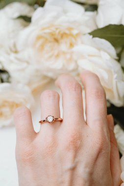 Yumuşak çiçekli bir kadının elinde nişan yüzüğü.