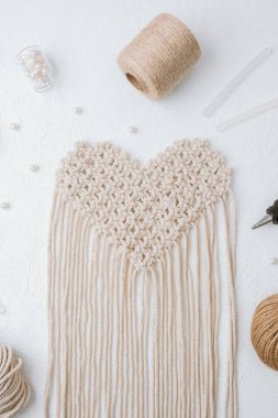 Beyaz arka planda tutkal tabancası ve kablosu olan kalp makromu.