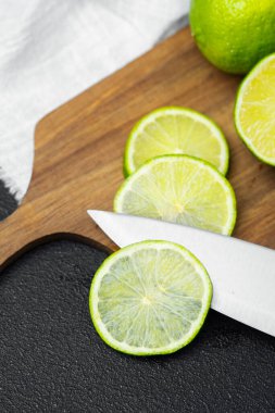 Sulu limonlar parlak bir mutfak ortamında ahşap bir kesme tahtasıyla dilimlenir..