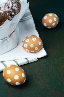 Yeşil arka planda papatya yumurtalı pudra şekerli Paskalya pastası.