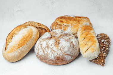 Temiz bir yüzey üzerinde çeşitli zanaatkar ekmekleri bir arada sergilenir.