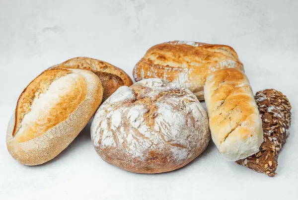 Temiz bir yüzey üzerinde çeşitli zanaatkar ekmekleri bir arada sergilenir.