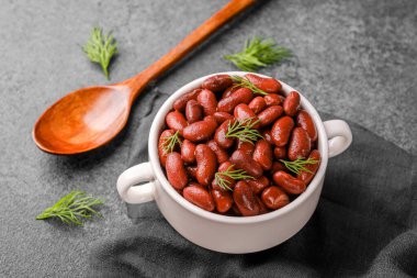 Vejetaryen protein, yemek pişirme ya da gıda malzemesi konsepti için dereotu ve ahşap kaşıklı kırmızı böbrek fasulyesi.