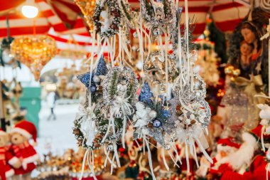 Noel pazarında mevsimlik hediyeler için ışıldayan çelenkler ve melekler. 