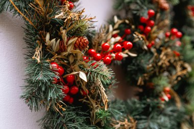 Noel tasarımı ve dekorasyon konsepti için çam, kırmızı böğürtlen ve kozalaklı bayram çelenklerinin kapanışı