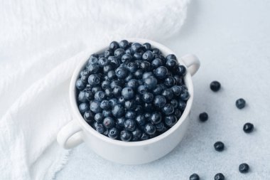 Rahatlık, diyet veya organik yeme konsepti için yumuşak kumaşlı yaban mersini kasesi.