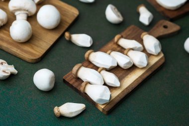 Hasat çeşitliliği veya vejetaryen pişirme konsepti için koyu yeşil arka planı olan çeşitli mantarlar.