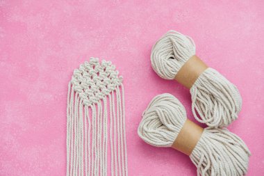 Pembe arka planda kordon skeins ile Macrame projesi