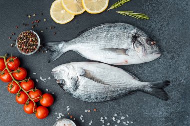 Siyah arka planda biberiyeli taze çiğ dorado balığını kapat.