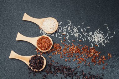 Siyah desenli yüzeyde siyah ve beyaz pirinçli kaşıklar.