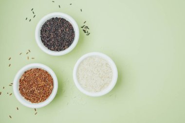 Yeşil zemin üzerinde seramik kaselerde siyah ve beyaz pirinç manzarası