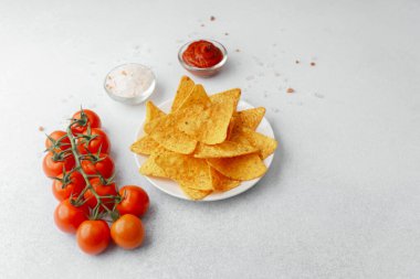 Domatesli çıtır cips, beyaz arka planda salsa ve tuz.