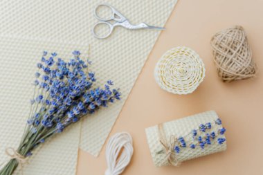 Mumlar malzemeler ve bej yüzeyde lavanta çiçekleri yapıyordu.