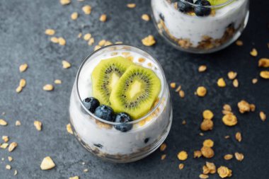 Koyu arkaplanda kivi ve yaban mersinli sağlıklı kahvaltı.