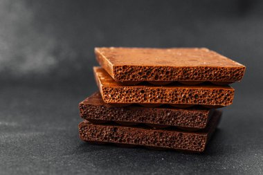 Koyu renkli sırtüstü havalanmış sütlü çikolata parçaları yığını.