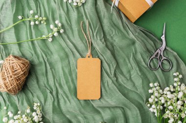 Çiçekli kraft etiketi ve hediye paketi aksesuarlarının üst görünümü