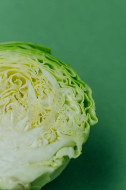 Yarım lahana üst görünümü düz yeşil arkaplan üzerinde yatıyordu