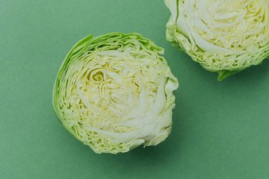 Yeşil arka planda iç dokuyu gösteren yarım yeşil lahana.