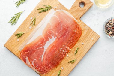 Jambon dilimleri tuz, otlar ve baharatlarla dilimlenmiş.