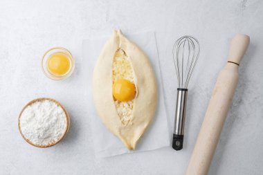 Yumurta sarısı ve beyaz arka planda çırpılmamış khachapuri.