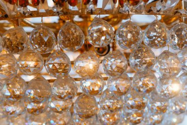 Kristal süsler bir avizeden sarkır, sıcak ışığı güzel yansıtır..