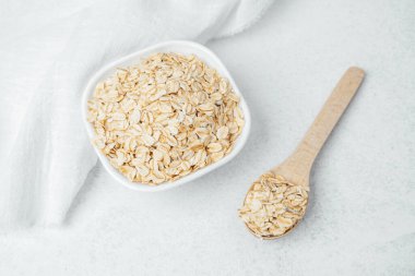 Çiğ yulaflar tahtadan bir kaşıkla besleyici yemek tarifleri için bir kasede sergilenir..