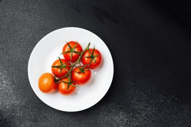 Beyaz bir tabakta sulu kırmızı domatesler basit ama canlı bir görüntü yaratır..