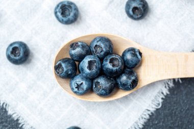Sulu yaban mersinleri ahşap bir kaşıkta toplanır. Kırsal bir kumaşa karşı..
