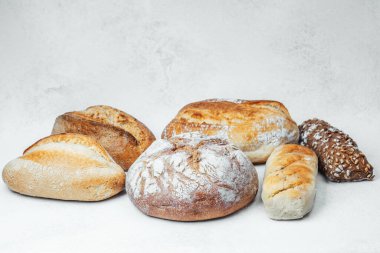 Açık bir yüzeyde çeşitli ekmekler güzel bir şekilde düzenlenmiştir..
