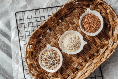 Örülmüş bir tepside kaselerde sergilenen farklı tohum türleri