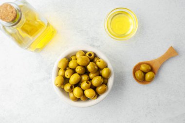 Cam şişeli yeşil zeytinler ve hafif arka planda yağ.