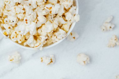 Bir kasede nefis patlamış mısır beyaz bir yüzeyde oturur ve samimi bir film deneyimini davet eder..