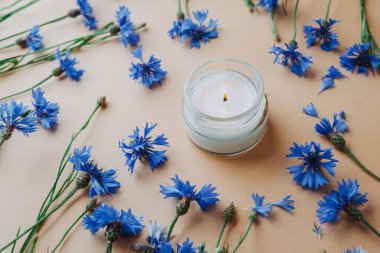 Bej arkaplanda mum ve çiçek