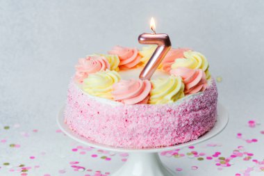 İçinde yedi numaralı mum ve konfeti bulunan renkli doğum günü pastası..