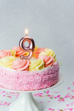 Dondurmayla süslenmiş renkli bir pasta ve dokuz numaralı mum özel bir doğum günü işareti..