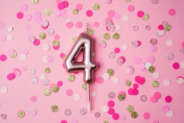 Canlı ekrana renkli konfetilerle çevrili dört numaralı mum sergileniyor..