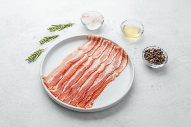 Pişmemiş pastırma şeritleri beyaz tabakta biberiye ve baharatla.