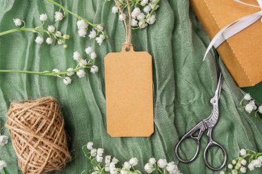 Çiçekli kraft etiketi ve hediye paketi aksesuarlarının üst görünümü