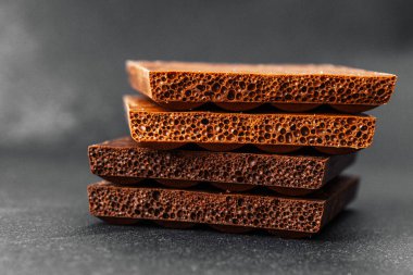 Koyu renkli sırtüstü havalanmış sütlü çikolata parçaları yığını.