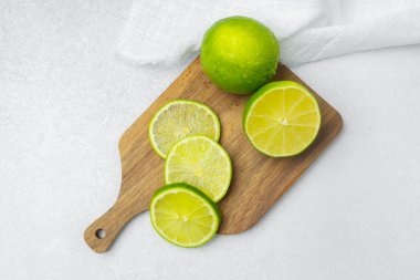 Taze limon dilimleri ahşap bir tahtanın üzerinde sergilenir..