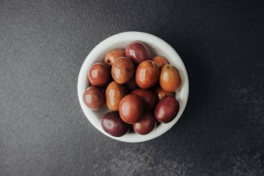 Siyah desenli masada kırmızı kalamata zeytinli kase.