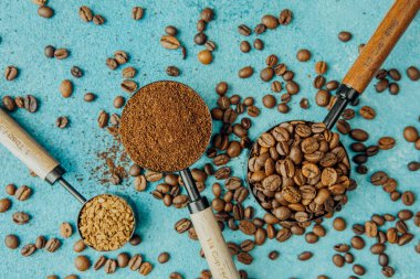 Kahve, hazır kahve ve mavi arka planda kepçelerle fasulye.