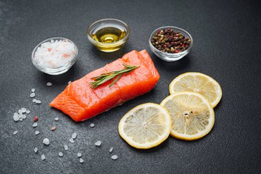 Somon filetosu yanında baharatlar, zeytinyağı, tuz ve limon dilimleri ile düzenlenir..