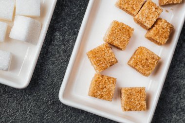 Kahverengi şeker ve beyaz şeker kalıplarda servis için düzgünce sergilenir.